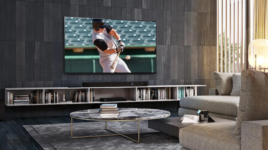 Media room cabinets and seating in front of a wall-mounted TV showing a baseball player hitting a ball.