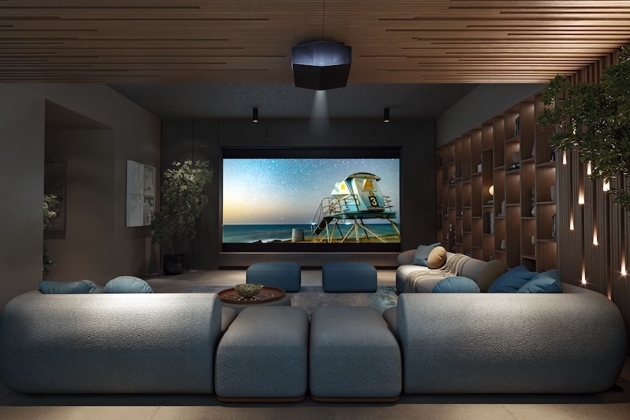 A home theater with gray sectional seating and a Sony projector.